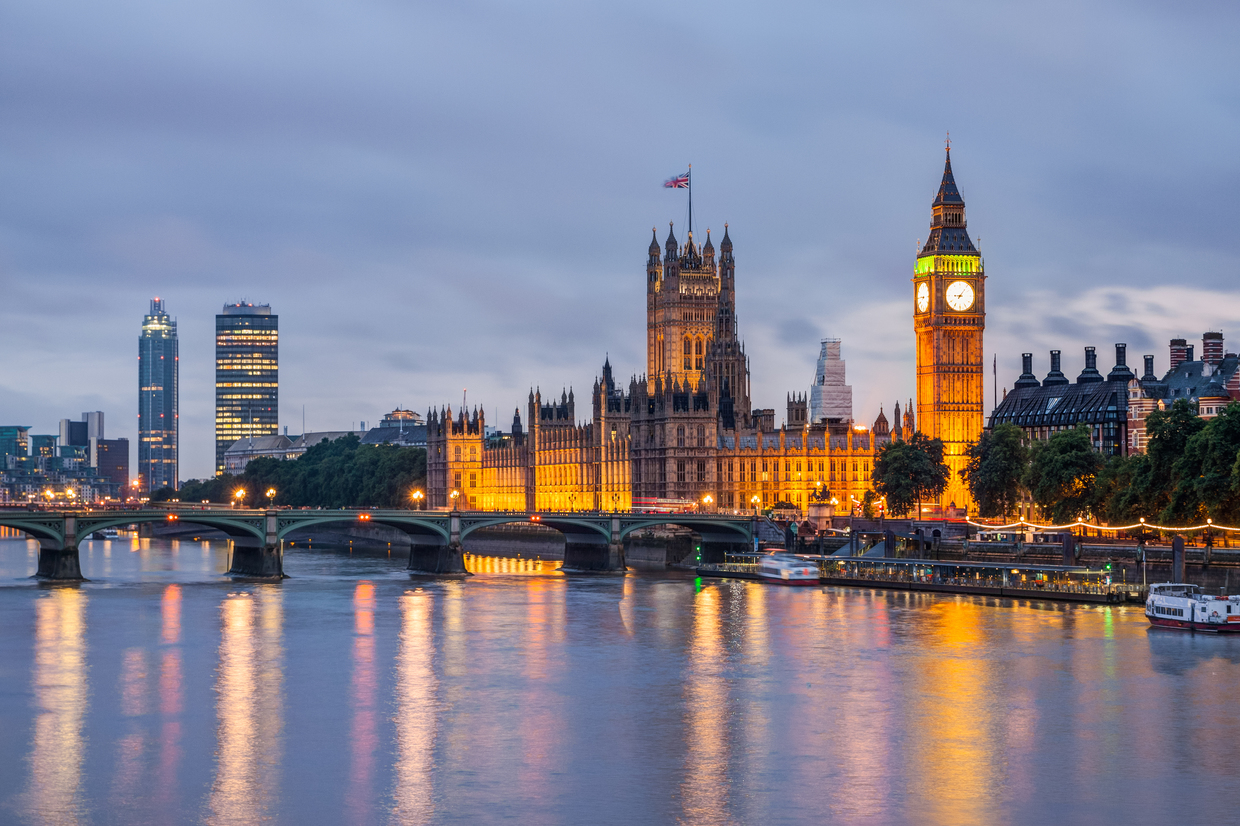 London’s Houses of Parliament and Big Ben beside the River Thames at dusk